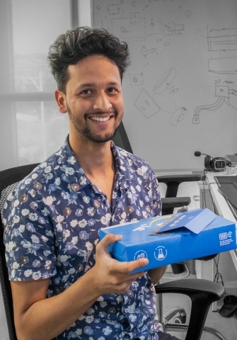 An employee from MRS is smiling after receiving a donut box from Dough With The Flow along with some cash gift| MRS Technologies Pakistan