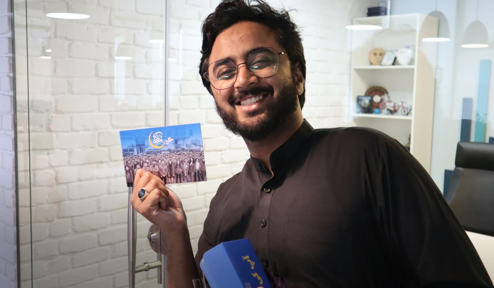 Hassan Mehmood, an employee smiling a posting with his Eid card in front of CTO Office | MRS Technologies Pakistan