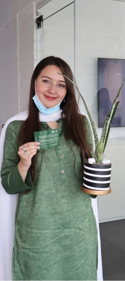 Rahat Javaid, an employee at MRS Technologies holds a green snake plant which was given to all employees by the company on Pakistan's Independence Day | MRS Technologies Pakistan