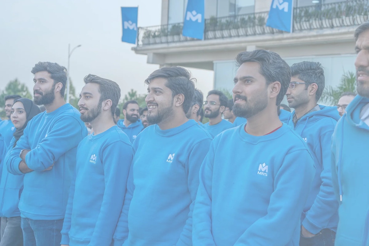 MRS Technologies Pakistan employees wearing blue hoodie celebrating | MRS Technologies Pakistan