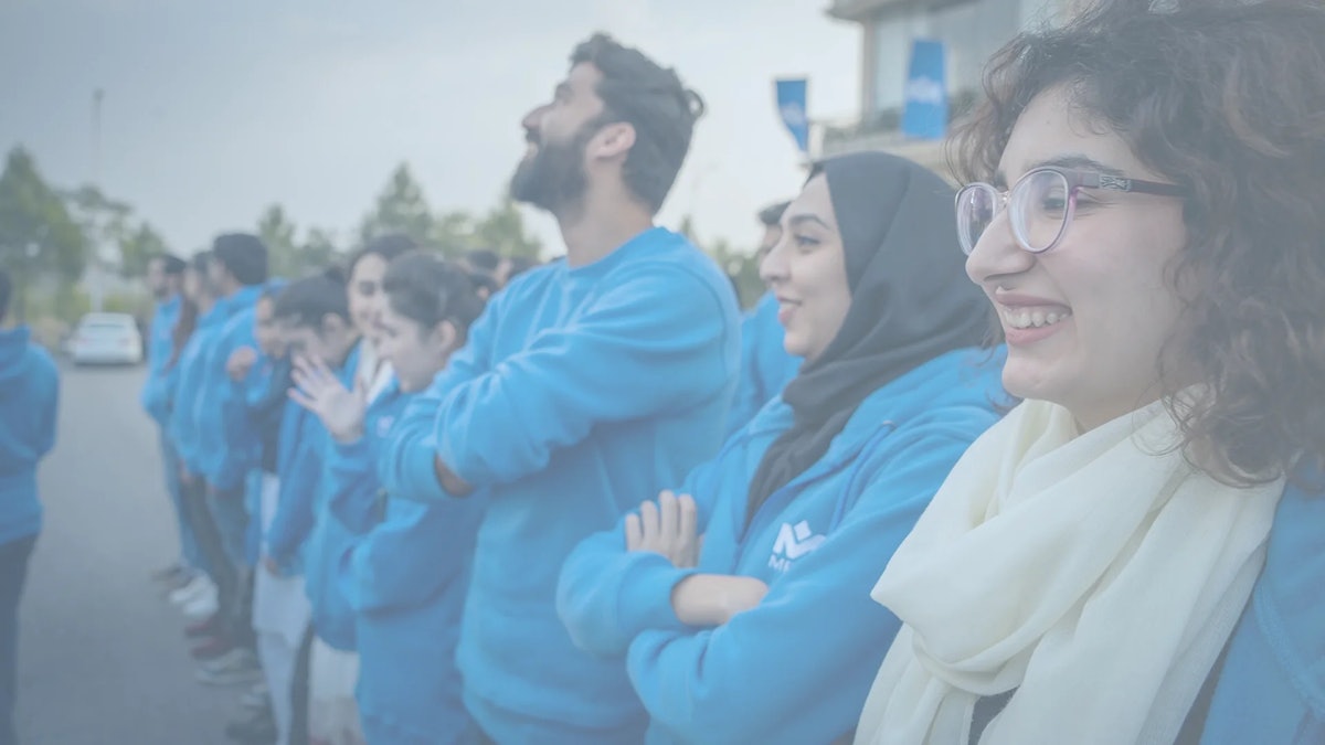 MRS Technologies Pakistan female employees wearing blue hoodies celebrating | MRS Technologies Pakistan