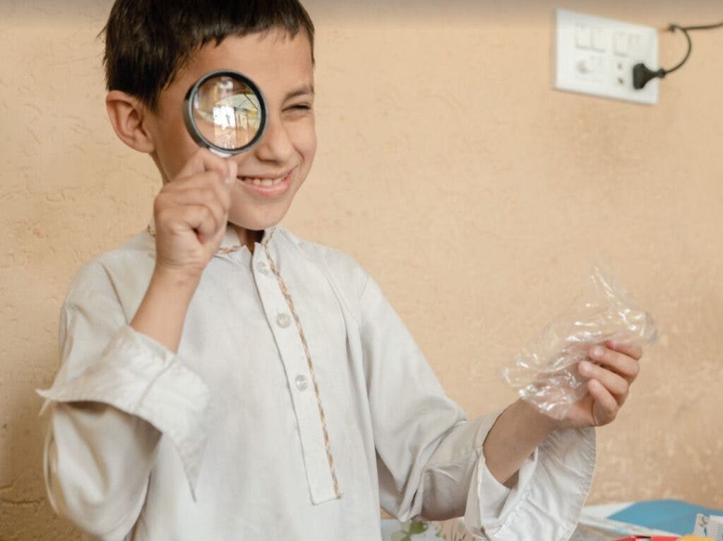 Child playing with magnifying glass donated | MRS Technologies